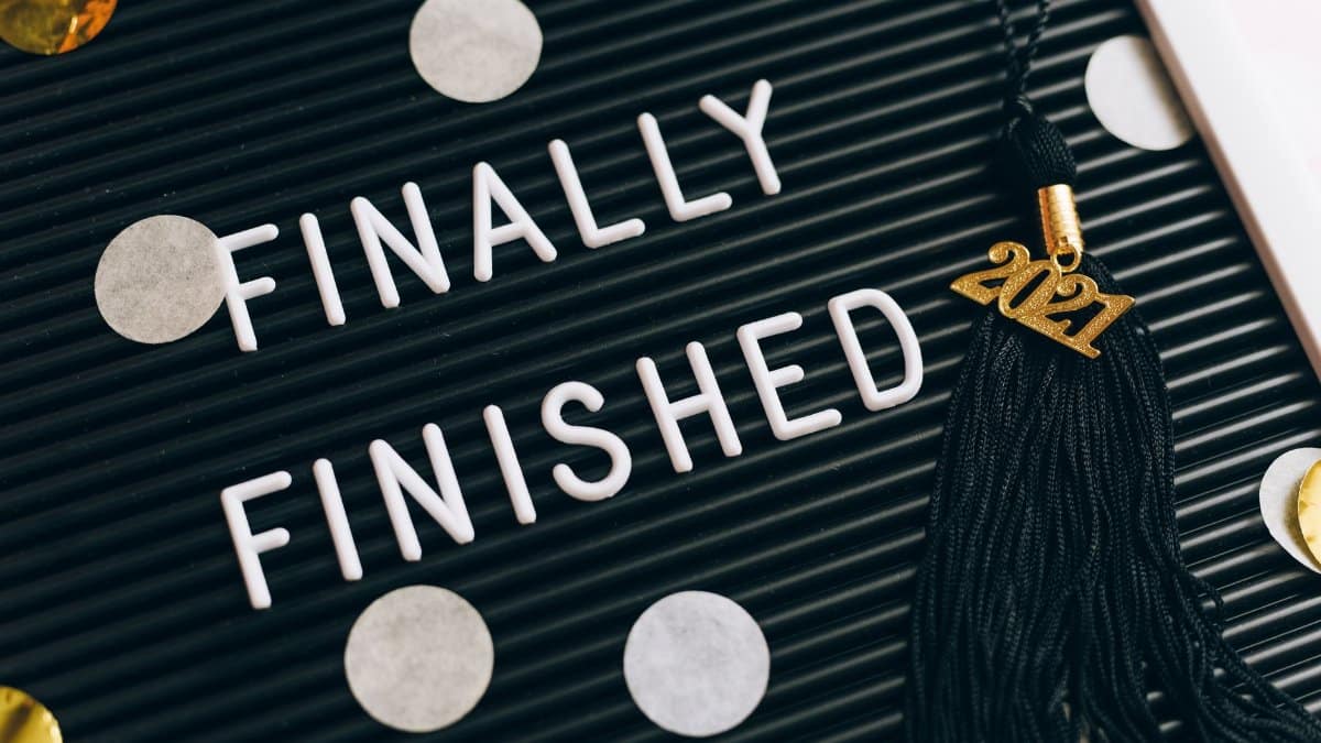 Close-up of a letter board with 'Finally Finished' text and 2021 graduation tassel.