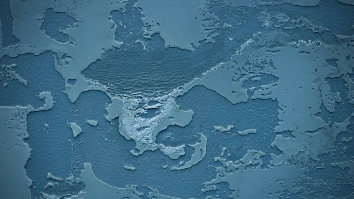 Textured blue plaster surface resembles a map with intricate details and patterns.