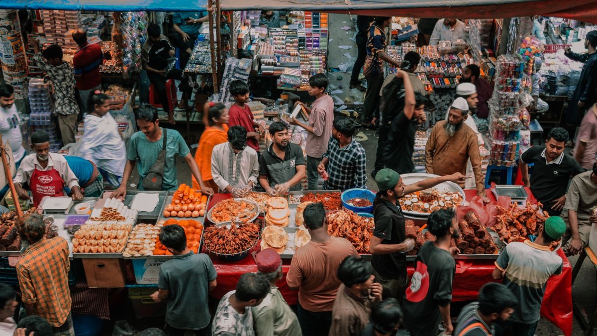 Vibrant street market filled with people and diverse street food stalls, capturing local culture.