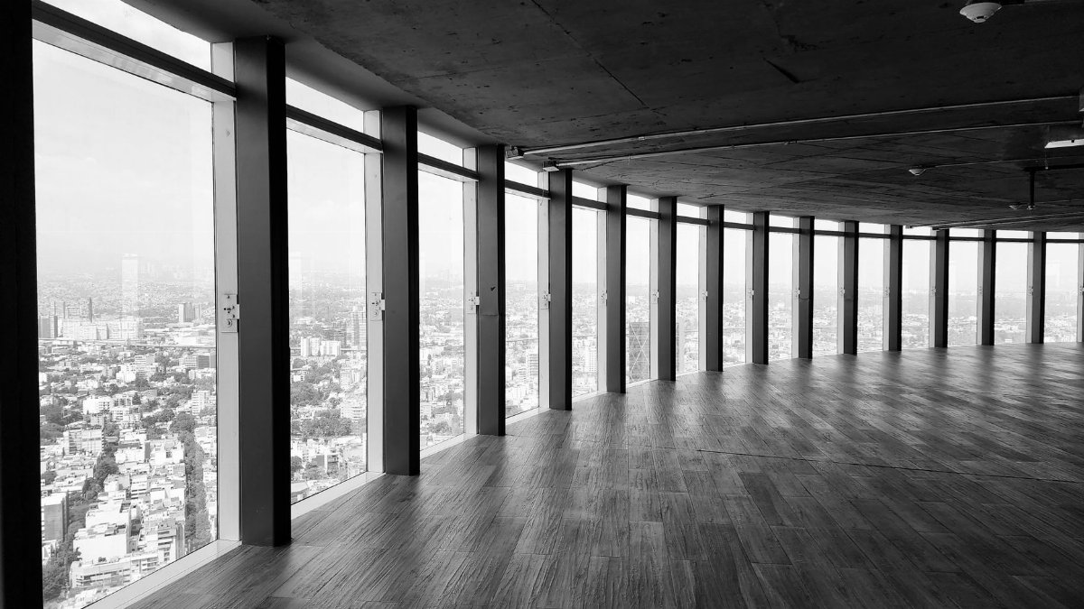 Spacious indoor view of a modern office with panoramic windows overlooking the city.