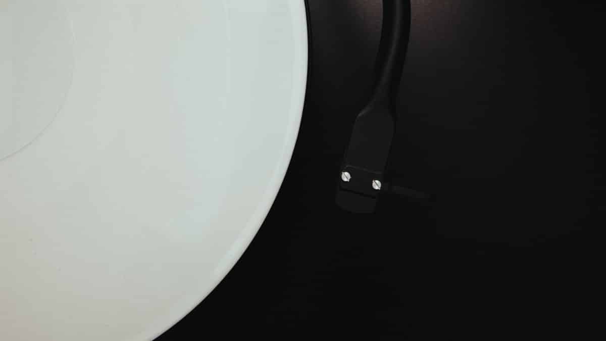 A striking minimalist shot of a white vinyl record on a turntable, evoking vintage vibes.