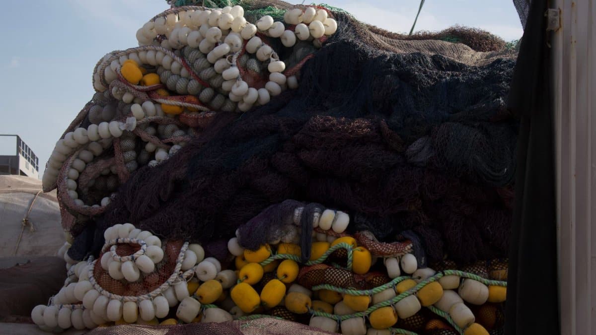 A pile of colorful fishing nets with floats, showcasing a vibrant outdoor setting.