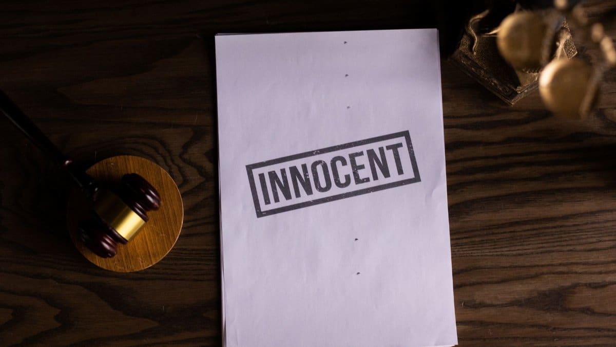 Close-up of legal document stamped 'Innocent' beside a gavel on a wooden desk.