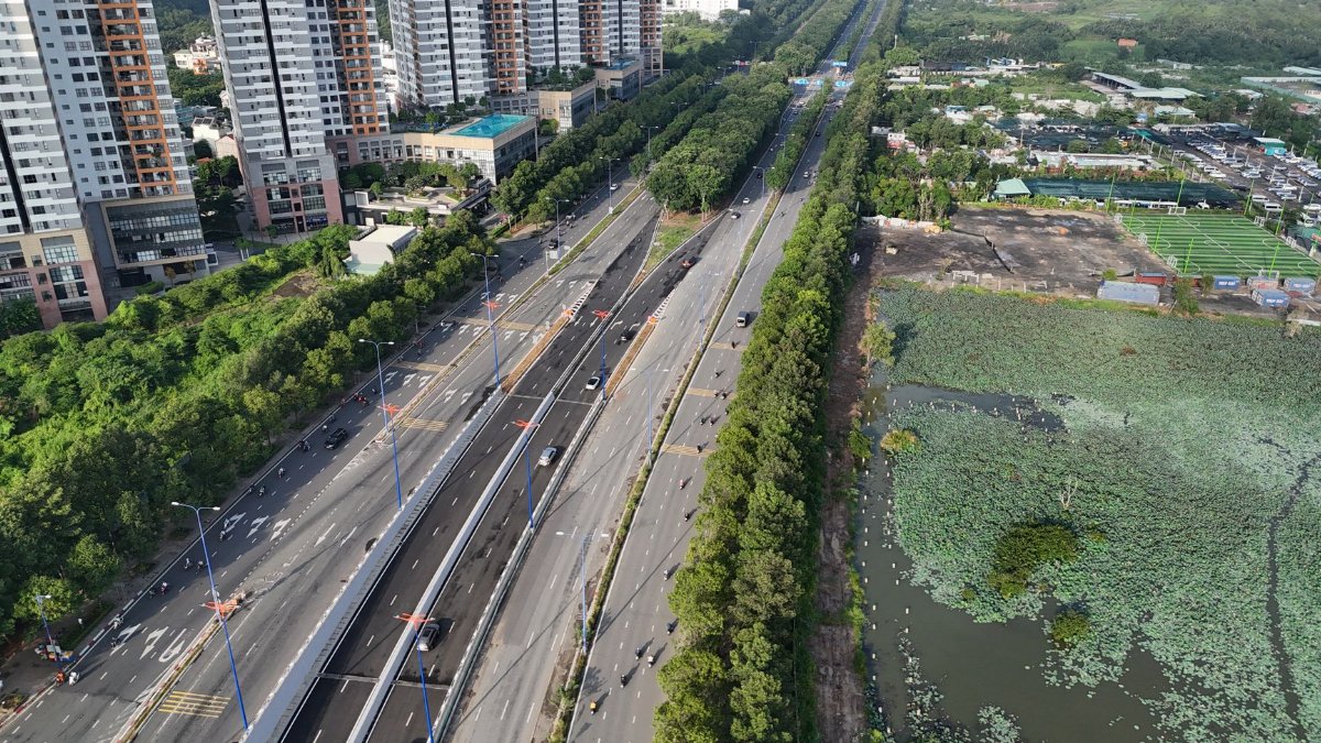 Aerial view of urban cityscape with high-rise buildings and wide highway in Ho Chi Minh City, Vietnam.
