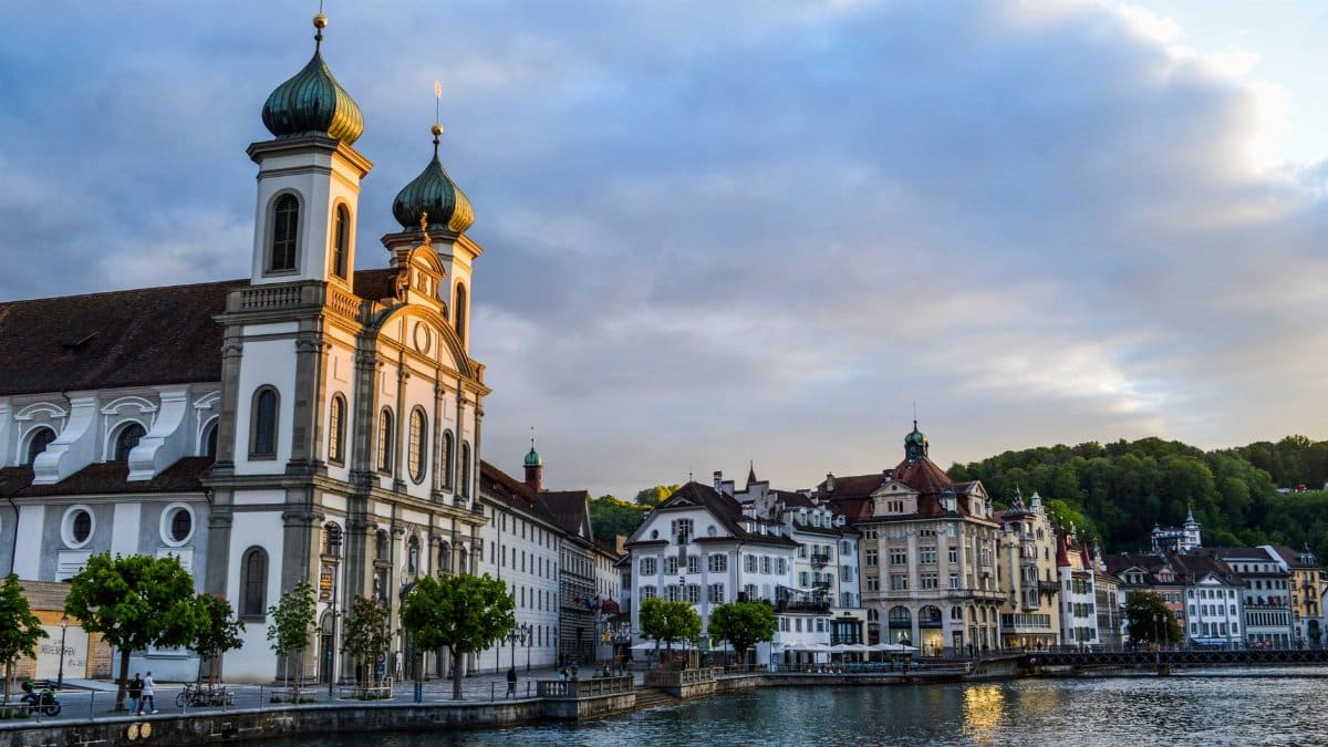 Majestic building of Jesuit Church with ornamental facade on coast of city channel in Lucerne