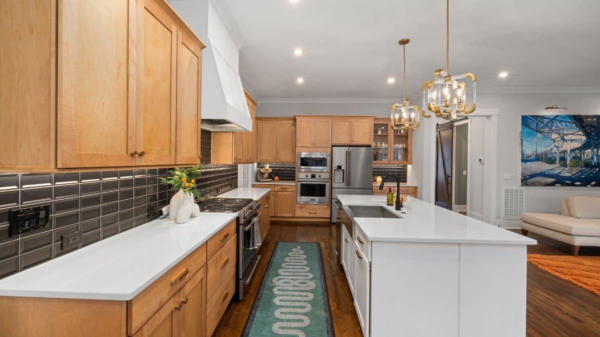Spacious kitchen featuring a central island, wooden cabinets, and stylish lighting.
