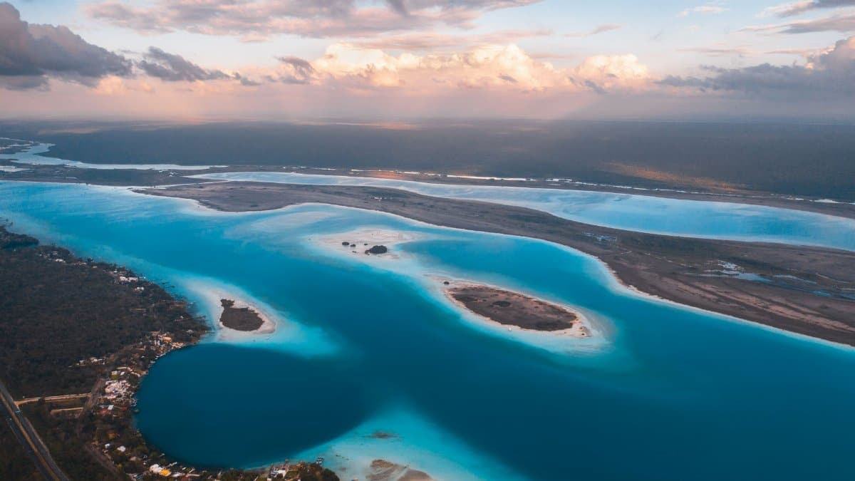 Breathtaking aerial view of a clear blue lagoon along the Mexican coastline at sunset.
