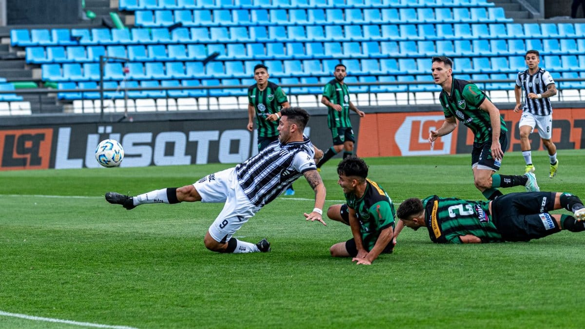 Players in an intense soccer match tackle each other on the field.
