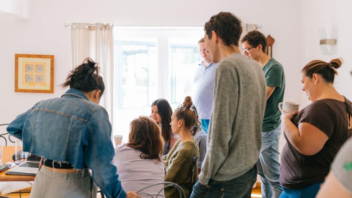 A group of adults collaborating around a table in a bright room, promoting teamwork and creativity.
