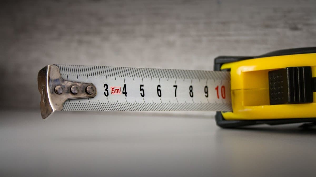 Detailed image of a yellow tape measure extended to 10cm on a neutral background.