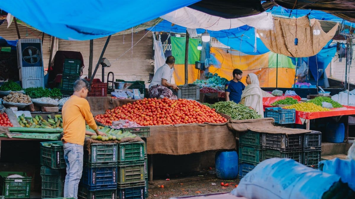 A lively outdoor market scene showcasing vendors selling fresh fruits and vegetables.