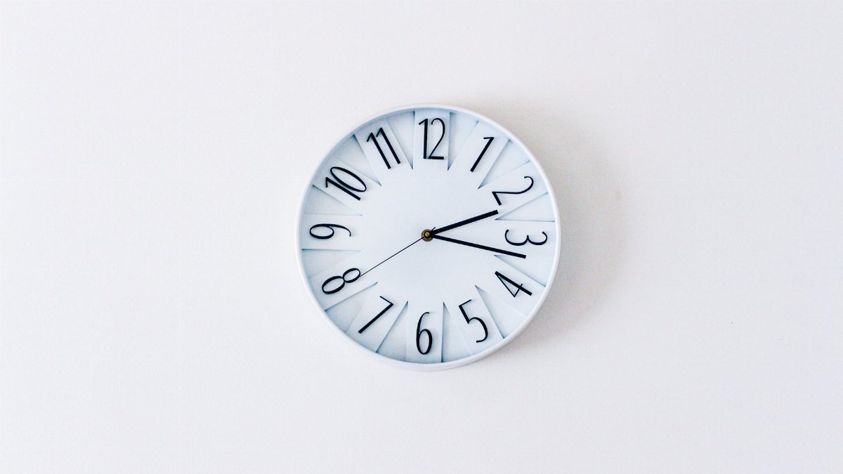 Simple minimalist wall clock on a white wall for a clean aesthetic.