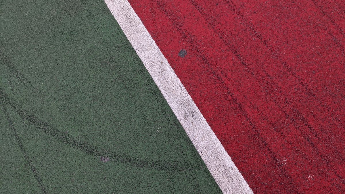Abstract view of vibrant green and red court lines at a sports field in Kyiv.