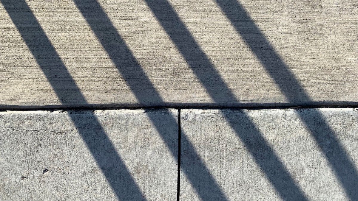 Abstract representation of geometric shadow patterns on a concrete surface.