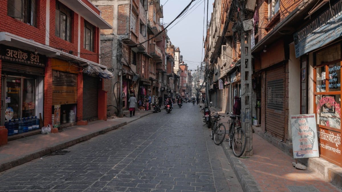 Bustling street with shops, bikes, and people in Kathmandu, Nepal.