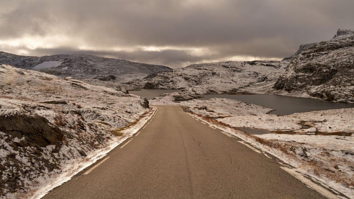 A tranquil drive through the snow-dusted Aurland landscape under cloudy skies.