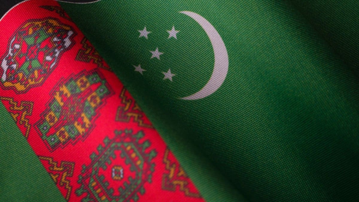 Detailed close-up of the Turkmenistan flag with its intricate patterns and vibrant colors.
