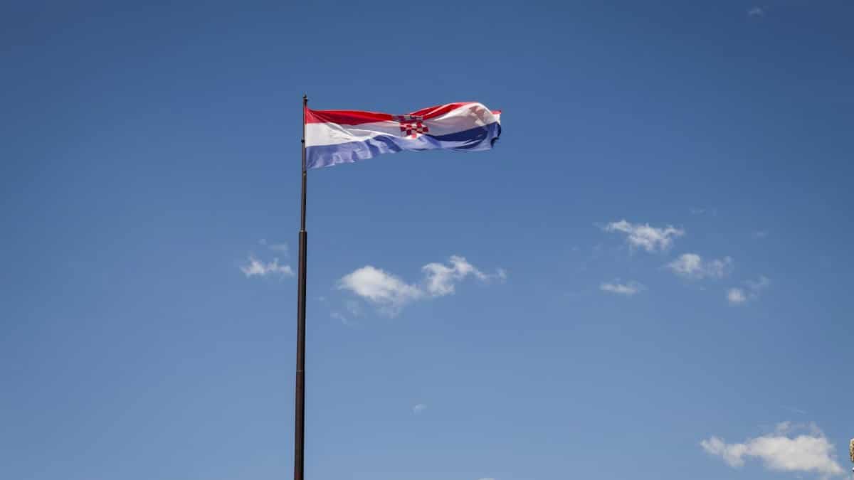 Croatian national flag waving against a clear blue sky in Split, Croatia.