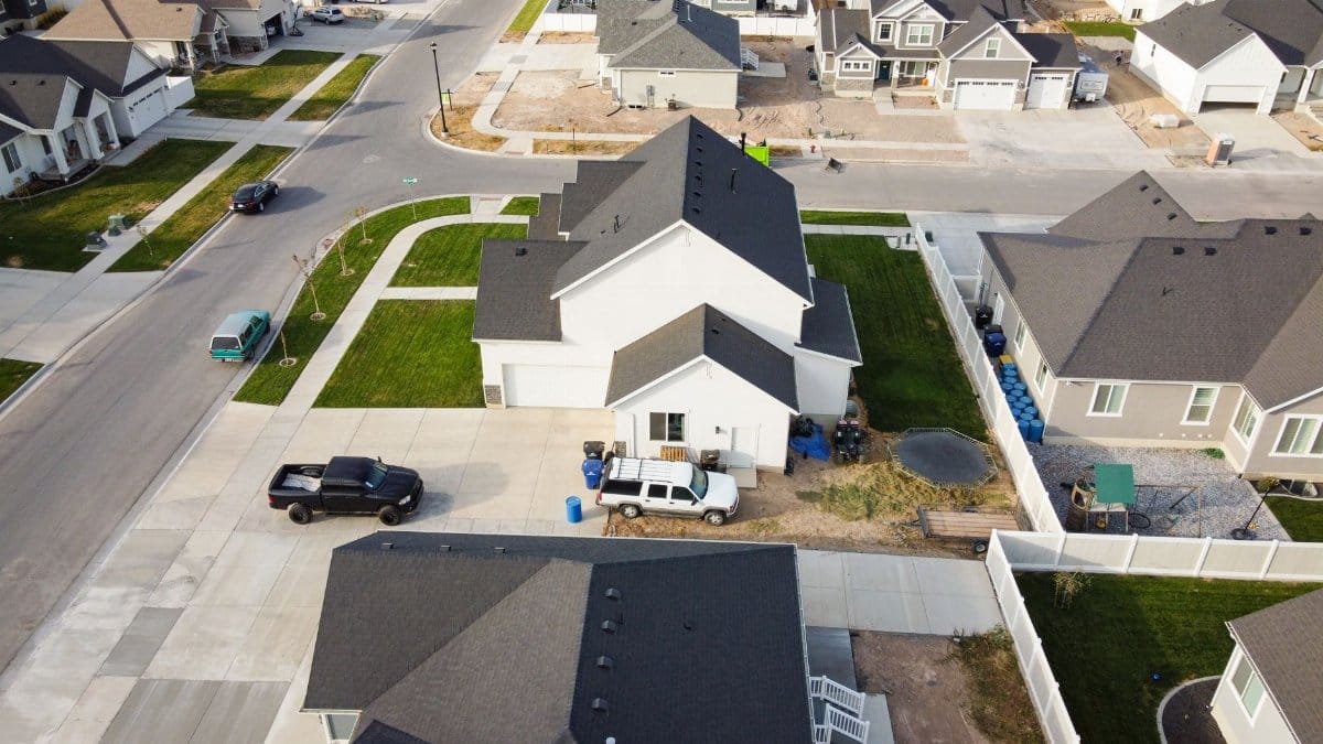Aerial view of a residential suburban neighborhood in Spanish Fork, Utah with houses and vehicles parked on driveways.