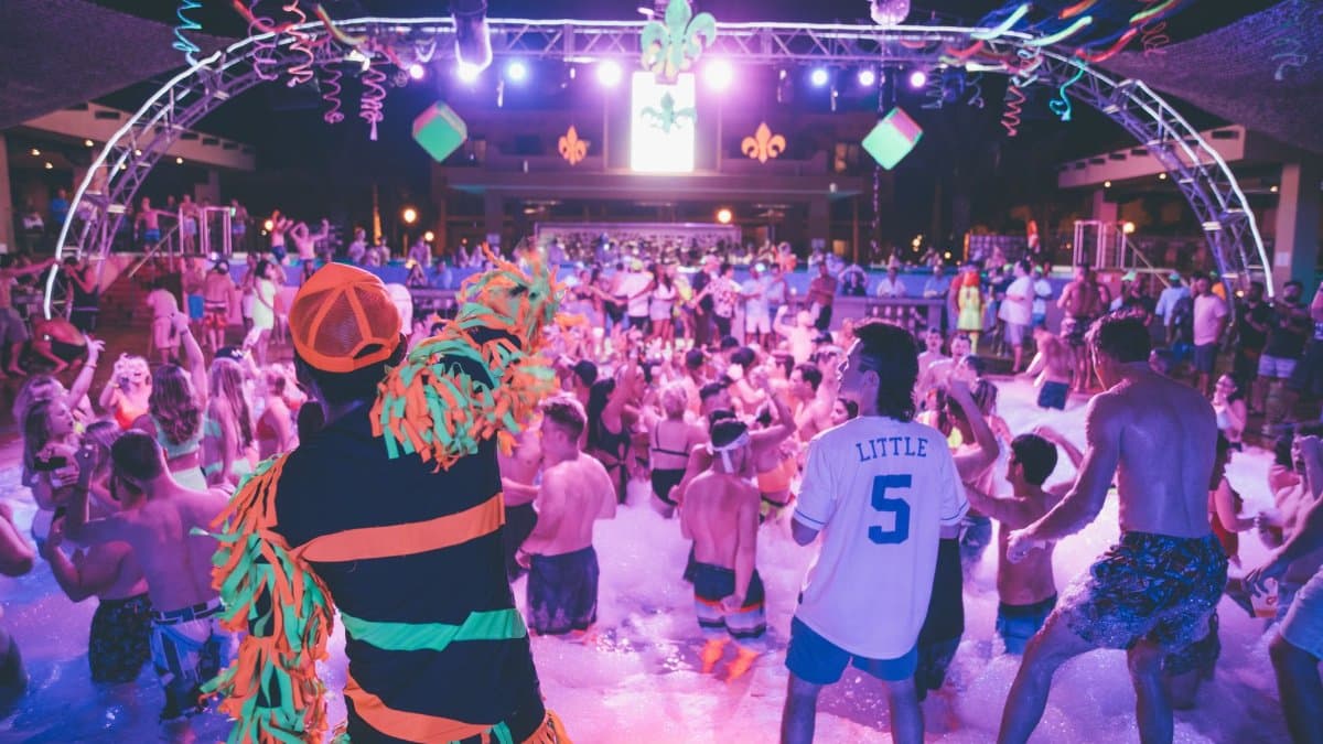 Energetic foam party at night with a lively DJ and young crowd enjoying the vibrant atmosphere.