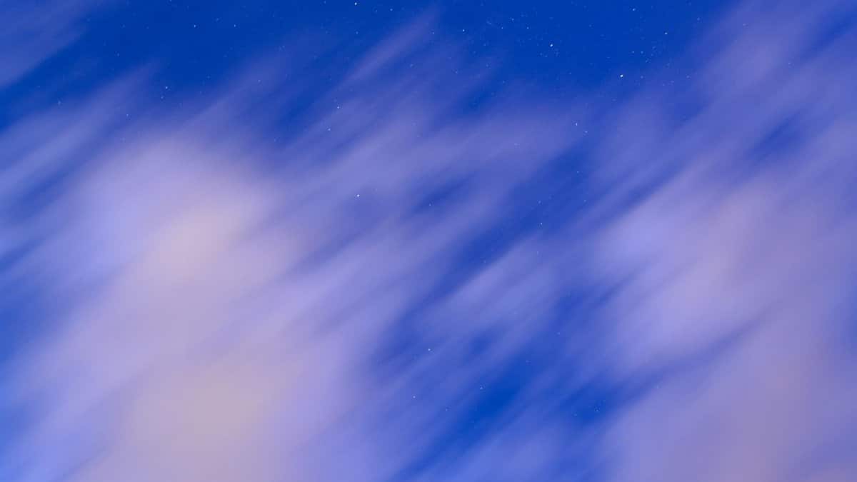 Abstract view of a night sky featuring blurred clouds and distant stars, creating a dreamy effect.