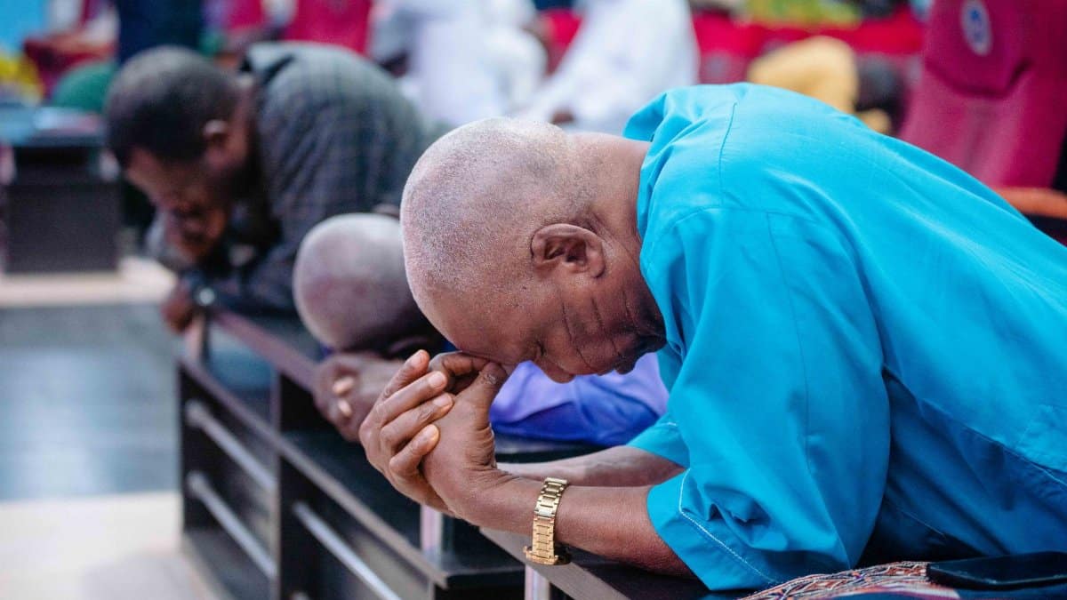 A group of men in deep prayer and devotion at a church in Ibadan, Nigeria.
