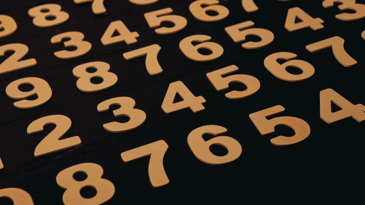 Close-up view of wooden numbers arranged on a black surface, ideal for educational themes.
