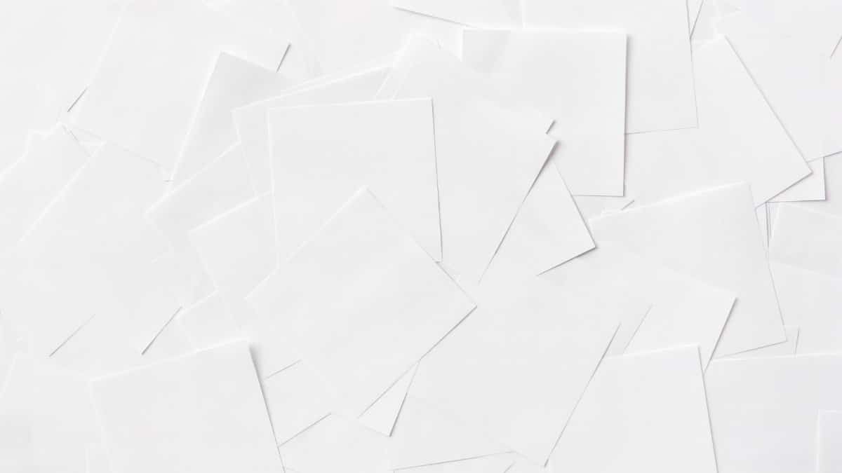 Overhead view of scattered white paper sheets creating an abstract pattern.