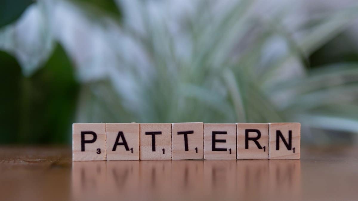 Scrabble tiles spelling 'Pattern' on a wooden surface with a soft-focus background.