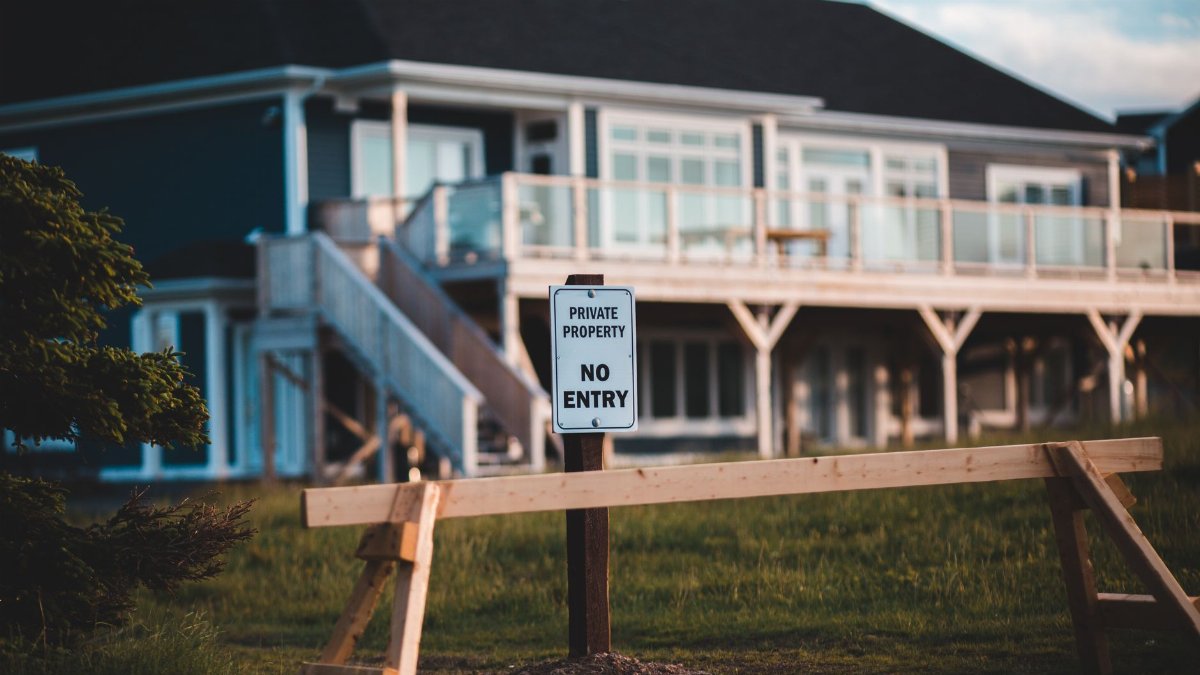 Sign indicating private property and no entry in front of modern house.