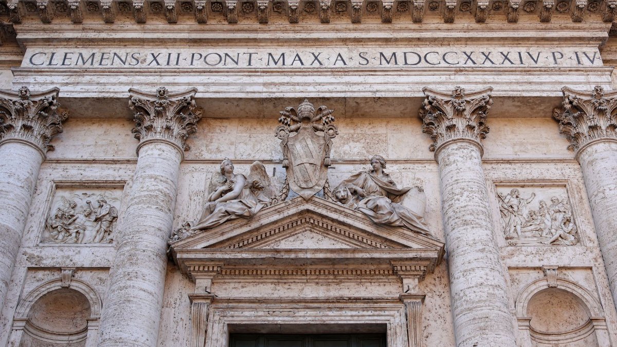 Detailed view of a Roman church's architectural facade with columns and sculptures in Rome, Italy.