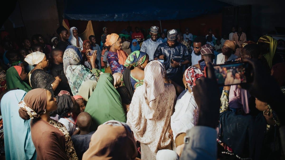 A lively gathering of diverse individuals in traditional attire, sharing joyful moments.