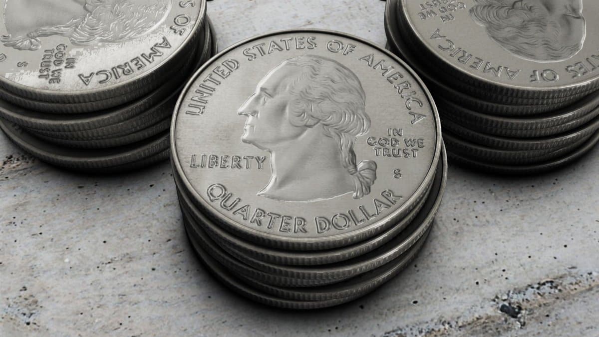 Detailed image of stacked silver US quarter coins showing engraved design.