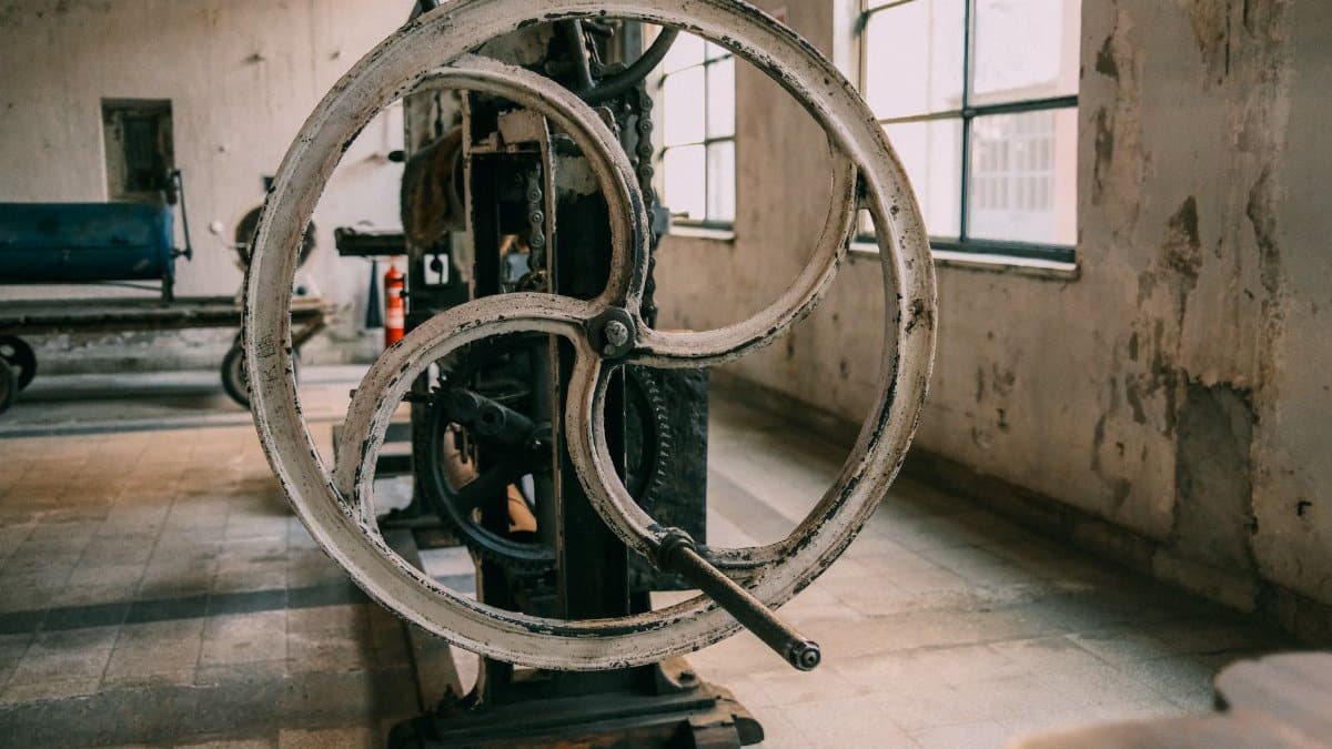 Close-up of a vintage industrial machine in an abandoned factory setting.