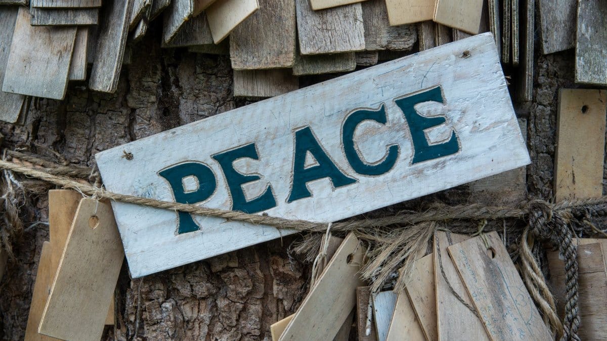 Wooden peace sign on rustic wooden background, symbolizing tranquility and harmony.