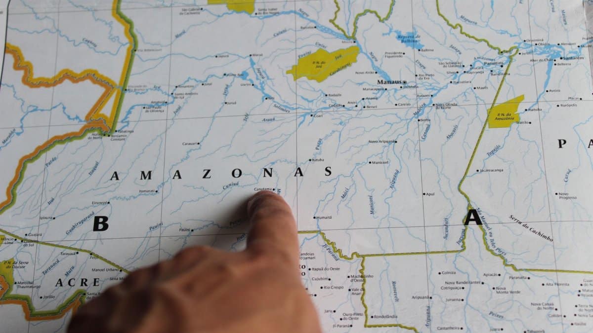 Photo of a hand pointing at Amazonas on a detailed map of Brazil.