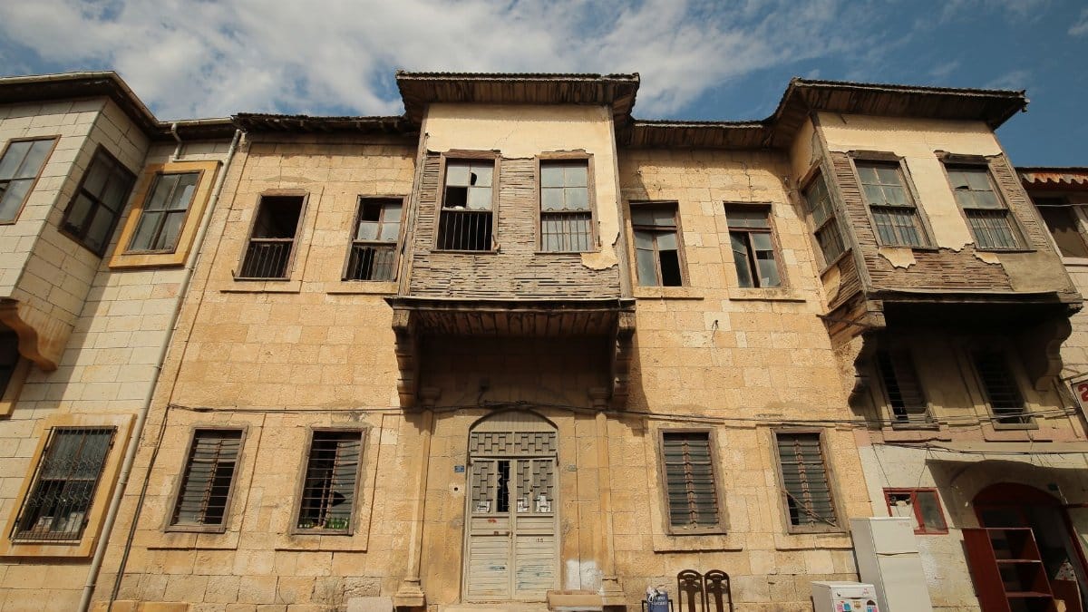 A weathered, abandoned building showcasing its rustic, historical architecture under a blue sky.