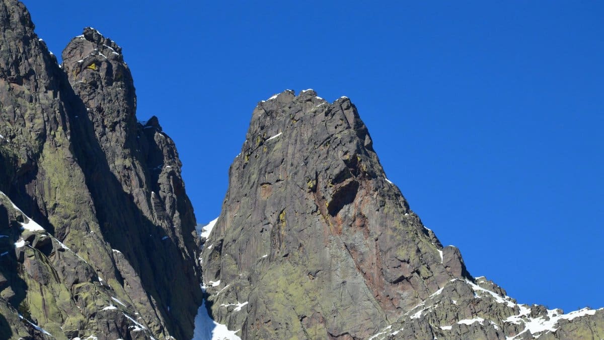 A stunning view of the rugged rocky peaks in Asco, set against a vibrant blue sky.