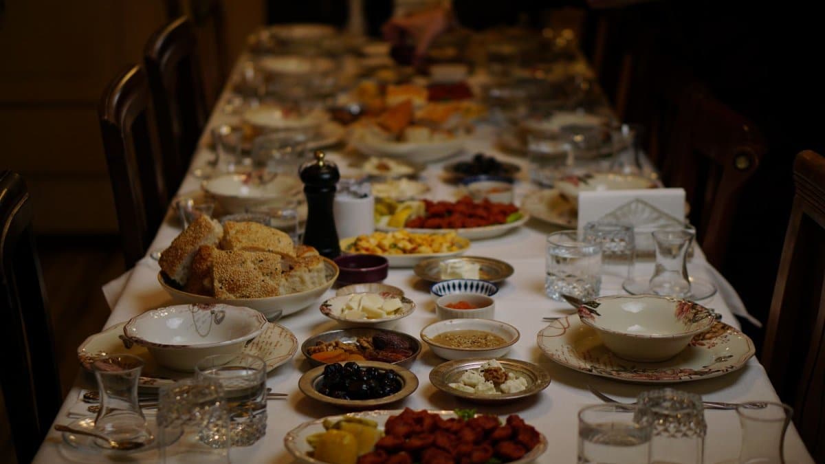 An elegantly set dinner table with various traditional and festive dishes for a gathering.