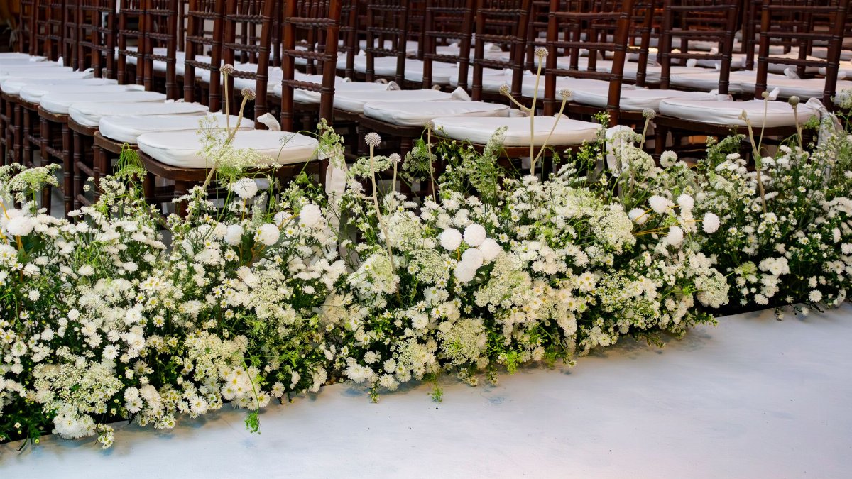 Elegant wedding setup featuring white flowers along the aisle in São Paulo, Brazil.