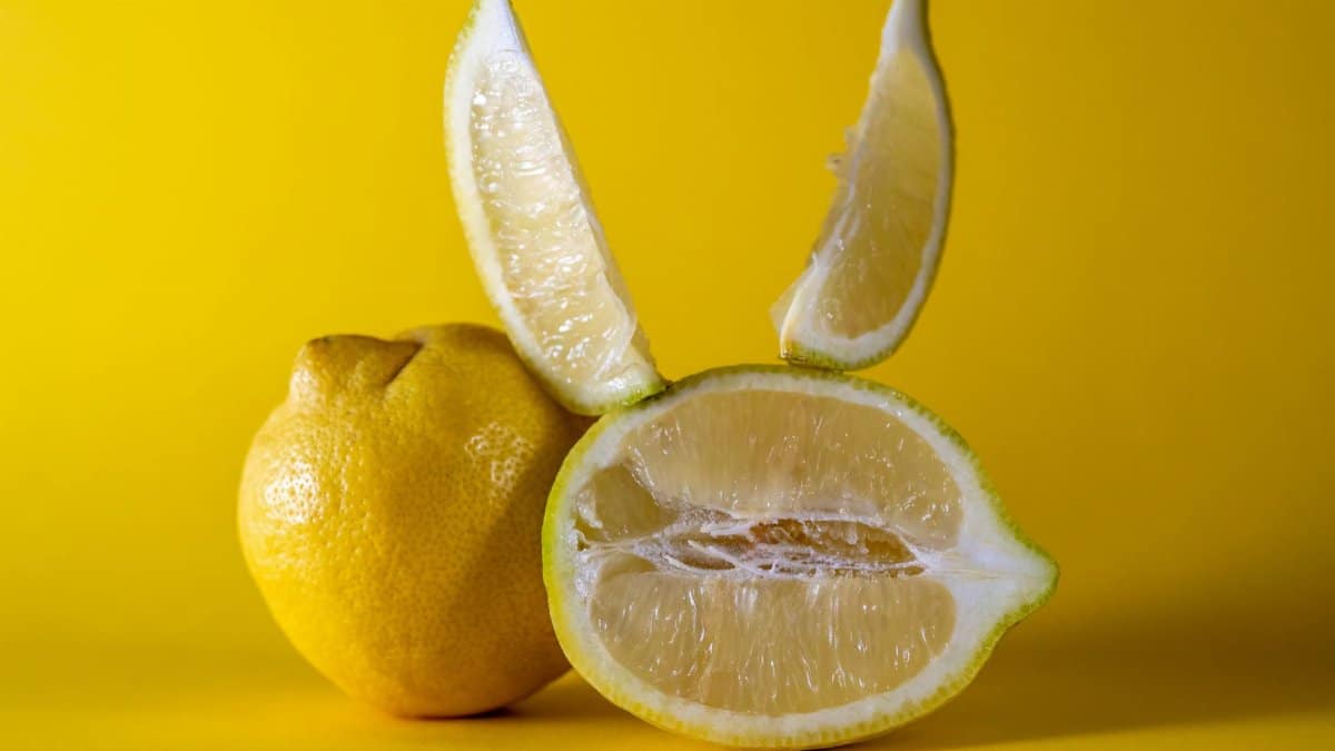 Close-up of fresh lemon slices creatively arranged on a vibrant yellow background. Perfect for food and health themes.