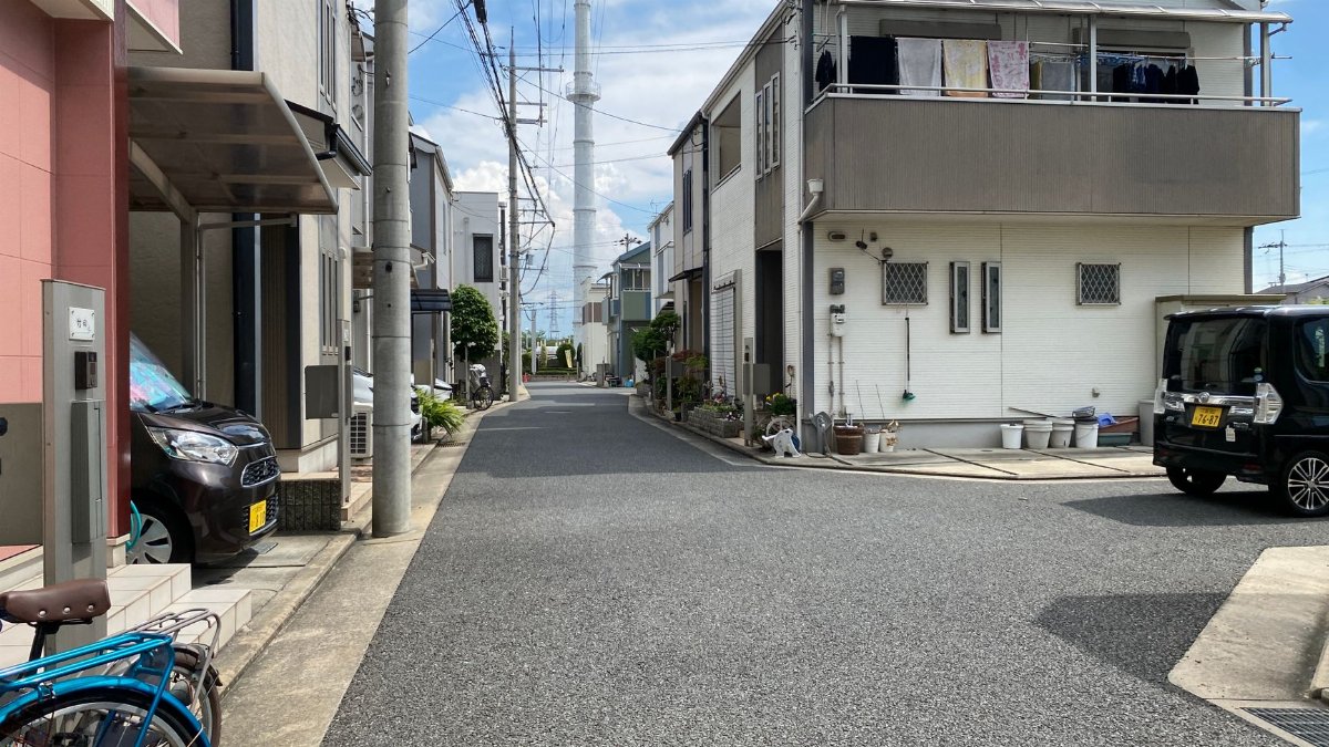 Calm urban scene showing modern houses along a quiet street on a sunny day.