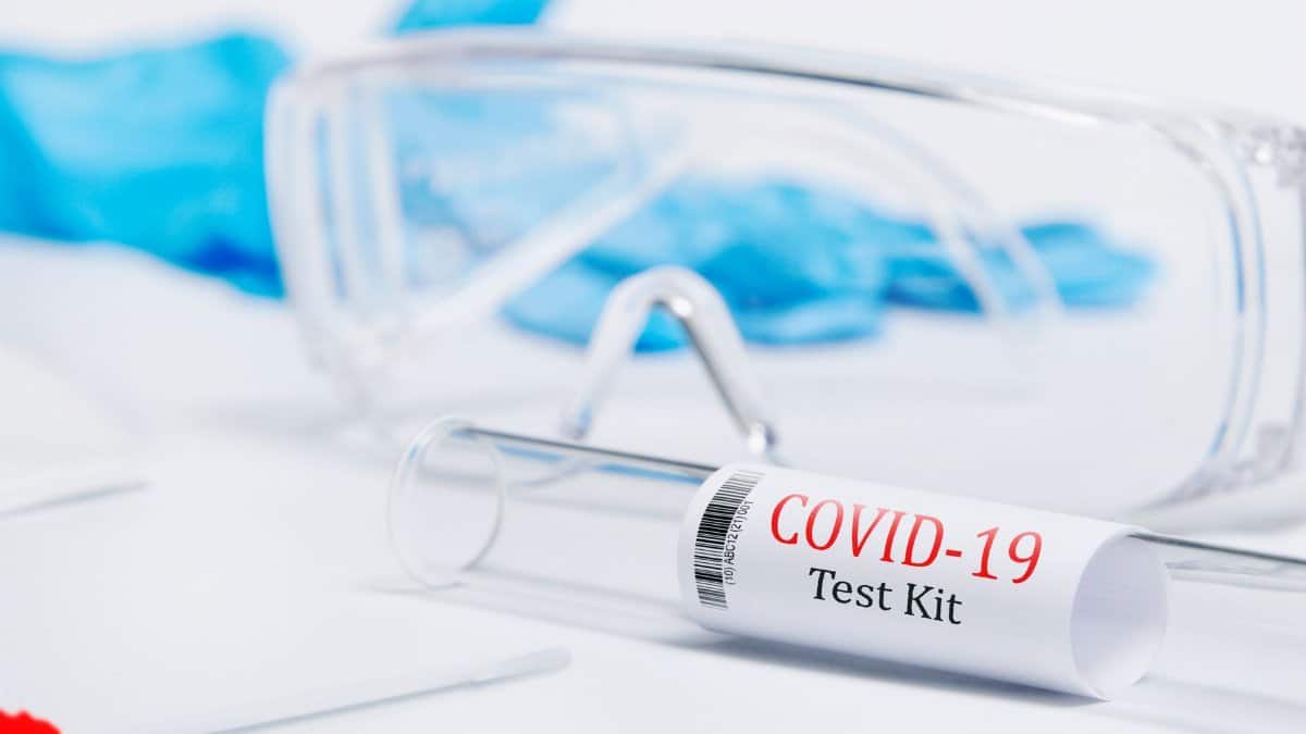 Close-up of a COVID-19 test kit with safety glasses and gloves, emphasizing safety in medical testing.