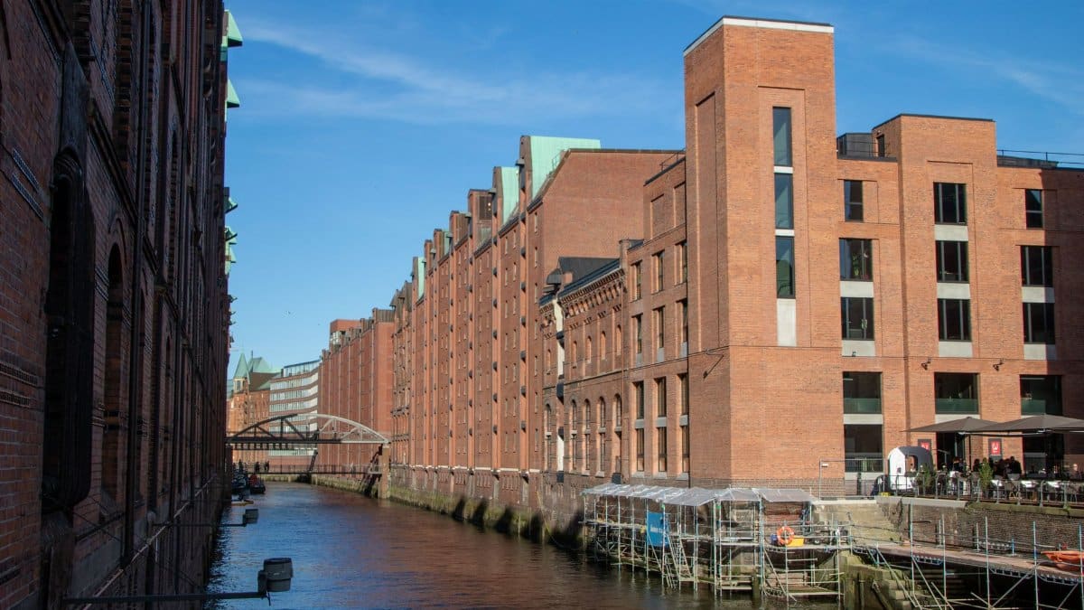 Scenic view of Hamburg's historic warehouse district with canal on a sunny day.