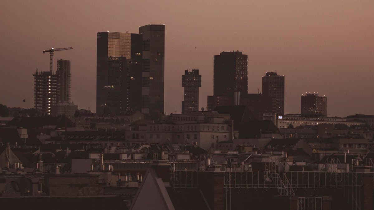 A city skyline at dusk featuring skyscrapers and a soft evening sky.