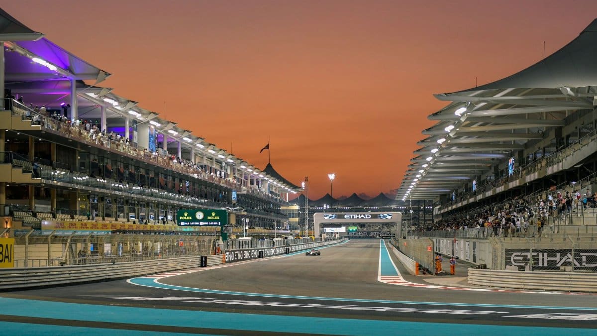 Formula 1 race event at Yas Marina Circuit, Abu Dhabi during sunset.