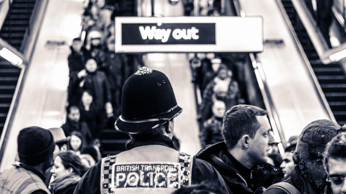 British Transport Police monitor a busy crowd in London Underground. Urban safety and public transit concept.