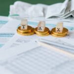 Close-up of tax forms, receipts, and coins symbolizing financial accounting and taxes.