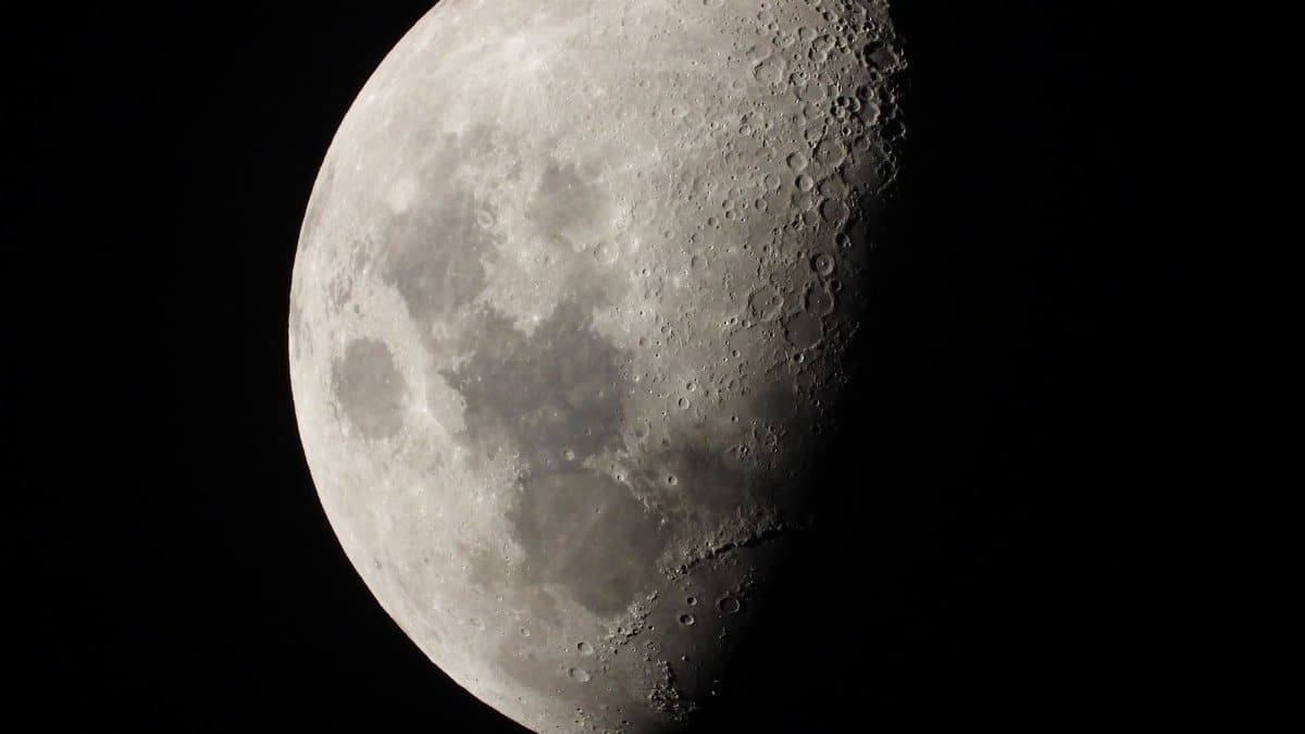 Detailed close-up of the moon's surface in the first quarter phase, showcasing craters and textures.