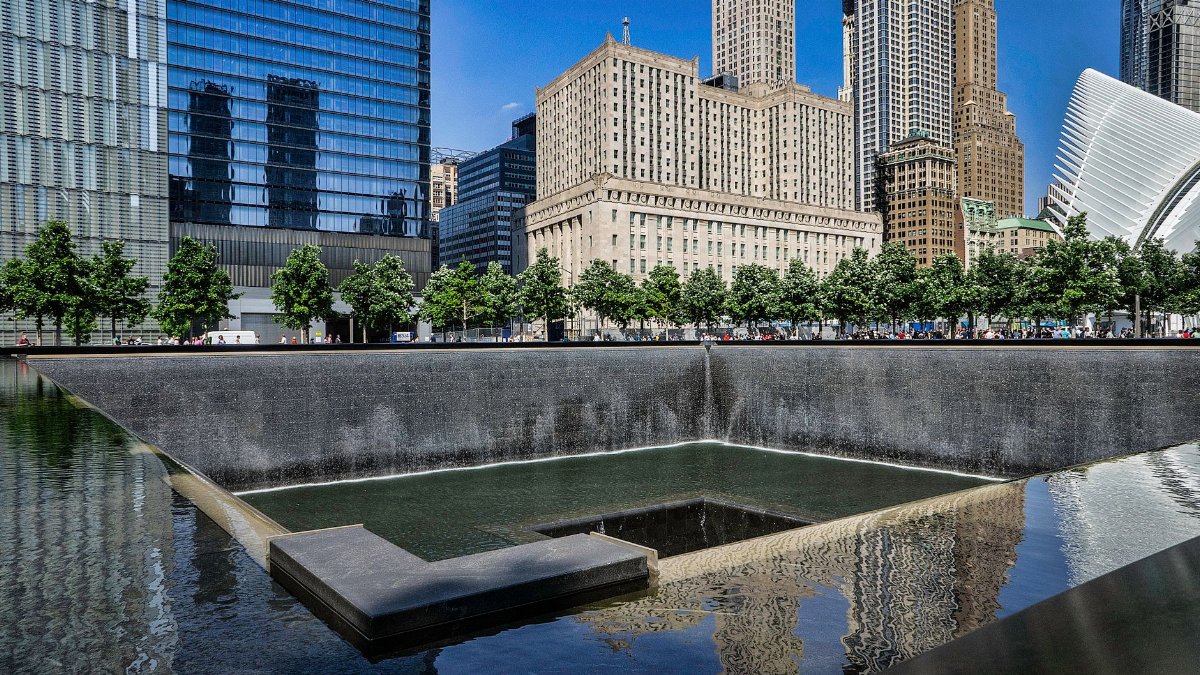 Stunning view of a city skyline with reflecting pool and vibrant urban architecture.